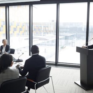 Corporate professionals engaged in a formal business meeting in a modern conference room setting.